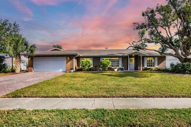 ranch-style house with a garage and a yard