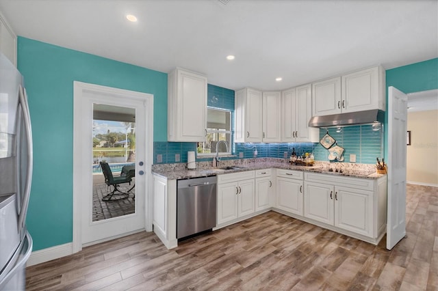 kitchen featuring light stone countertops, appliances with stainless steel finishes, sink, light hardwood / wood-style flooring, and white cabinets