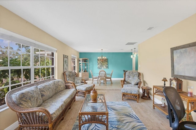 living room featuring light wood-type flooring and an inviting chandelier