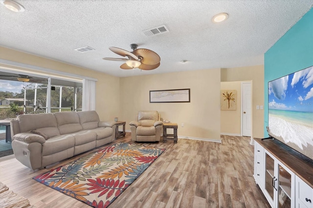 living room featuring a textured ceiling and light hardwood / wood-style flooring