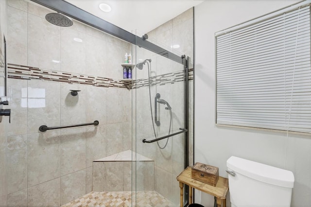 bathroom featuring toilet and an enclosed shower