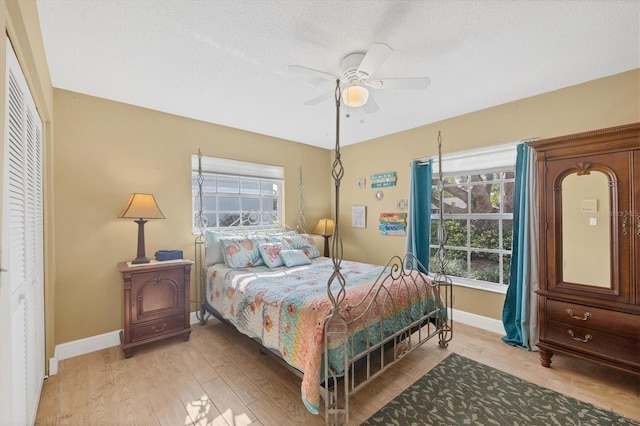 bedroom featuring hardwood / wood-style floors, ceiling fan, a textured ceiling, and a closet