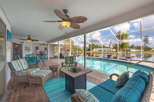 view of pool with a lanai, an outdoor living space, a water view, grilling area, and a patio