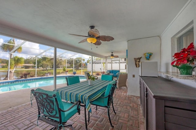 sunroom / solarium with ceiling fan and a swimming pool