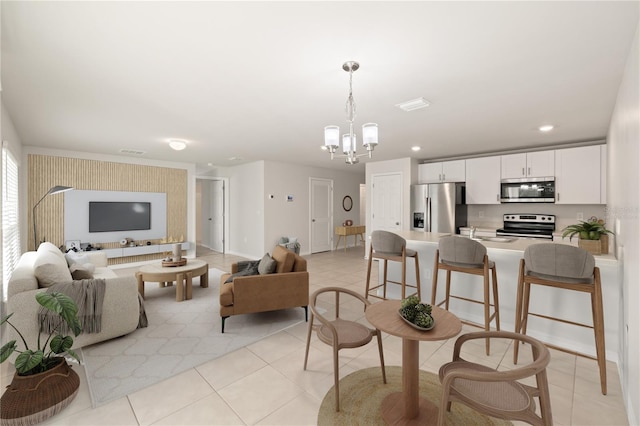 living room with light tile patterned floors and a notable chandelier