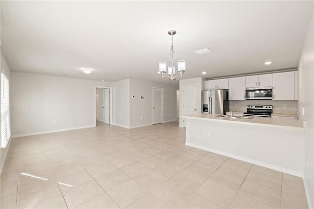 kitchen with white cabinetry, sink, hanging light fixtures, stainless steel appliances, and a notable chandelier