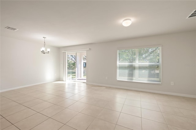 unfurnished room featuring light tile patterned floors and an inviting chandelier