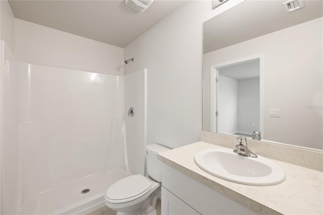 bathroom with vanity, toilet, and a shower