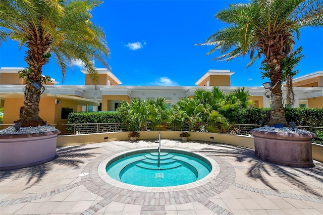 view of swimming pool featuring a hot tub and a patio