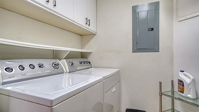 laundry room with electric panel, cabinet space, and washing machine and clothes dryer