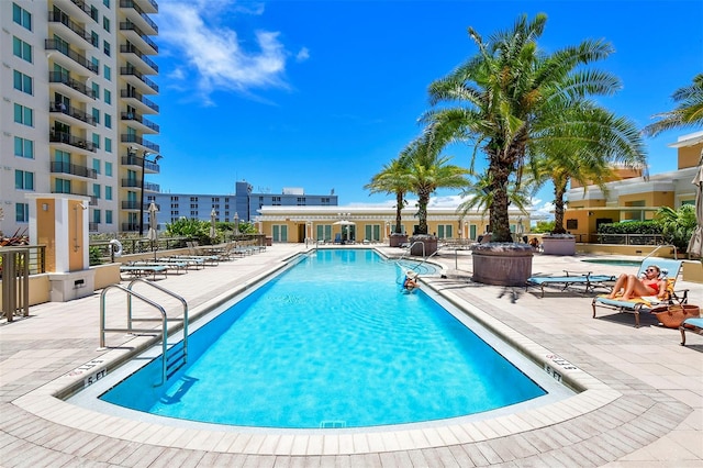 pool with a patio area and fence