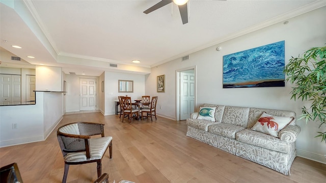 living room with ceiling fan, ornamental molding, and light hardwood / wood-style flooring