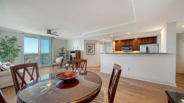 dining area with ornamental molding, a ceiling fan, recessed lighting, light wood-style floors, and baseboards