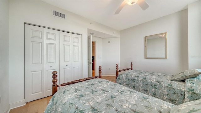 bedroom with visible vents, baseboards, ceiling fan, light wood-style flooring, and a closet