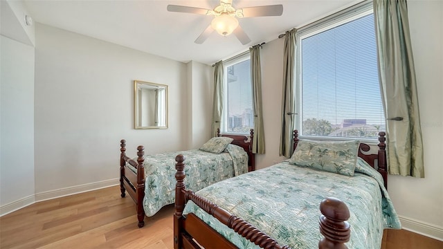 bedroom with wood finished floors, baseboards, and ceiling fan