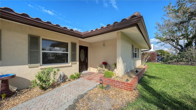 property entrance with a lawn