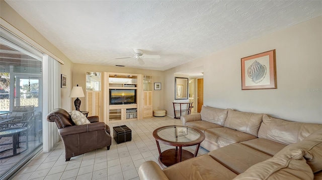 tiled living room with a textured ceiling and ceiling fan