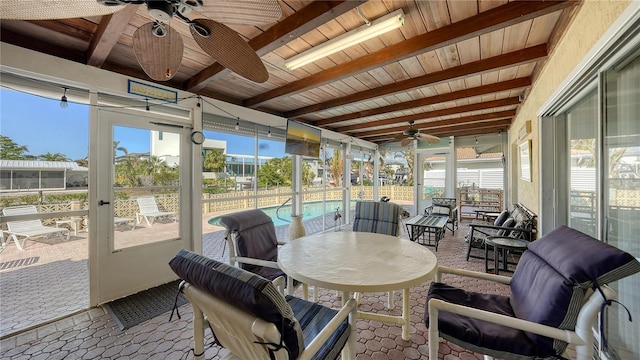 sunroom featuring beam ceiling, ceiling fan, and wooden ceiling