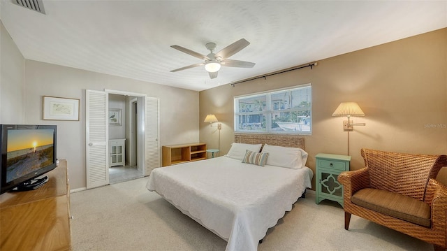 carpeted bedroom featuring ceiling fan and a closet