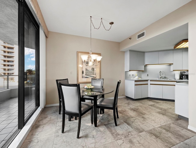 dining area with sink and a chandelier