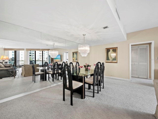 dining room with light carpet and a chandelier