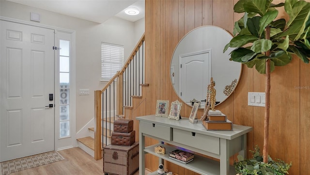 entrance foyer featuring light hardwood / wood-style flooring and wooden walls