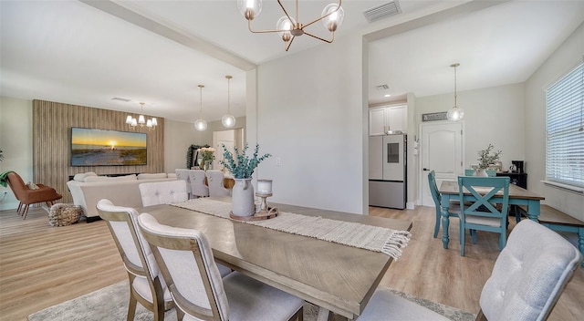 dining area with light wood-type flooring and a chandelier