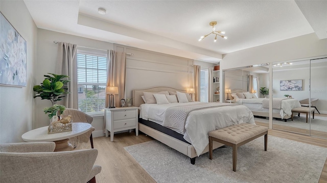 bedroom featuring light hardwood / wood-style flooring and a notable chandelier