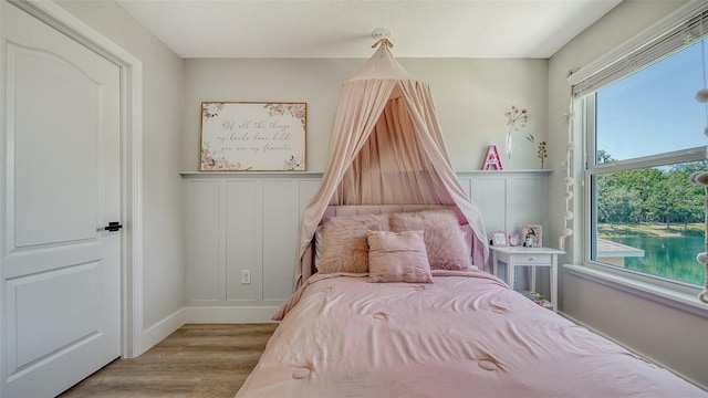 bedroom with light hardwood / wood-style flooring and multiple windows