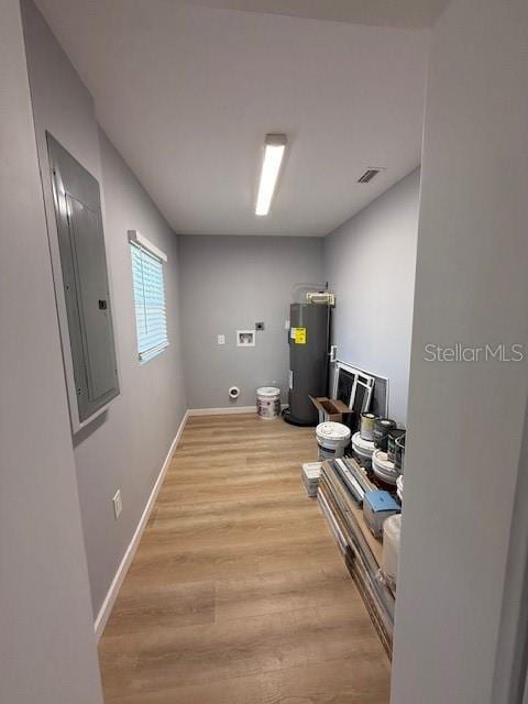 washroom featuring light hardwood / wood-style floors, washer hookup, electric water heater, and electric panel