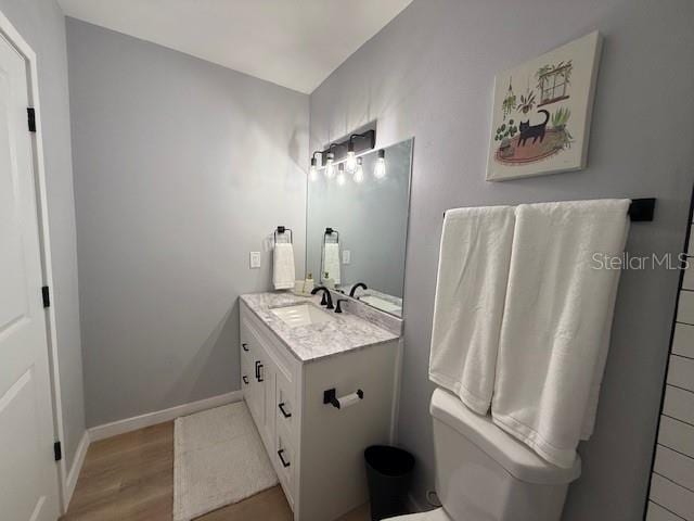 bathroom featuring hardwood / wood-style floors, toilet, and vanity