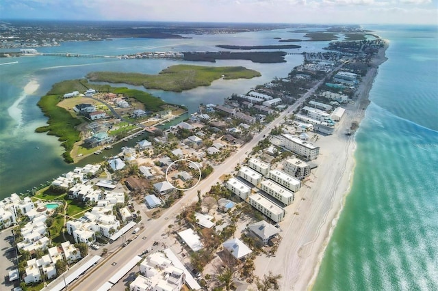 birds eye view of property featuring a water view and a beach view