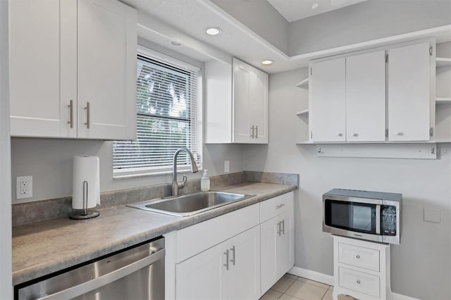 kitchen featuring stainless steel appliances, white cabinetry, a healthy amount of sunlight, and sink