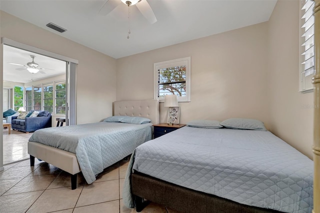 bedroom featuring multiple windows, ceiling fan, and light tile patterned floors