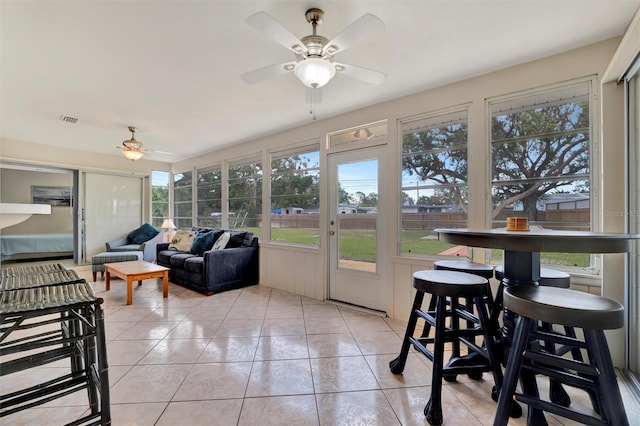 sunroom / solarium featuring plenty of natural light and ceiling fan