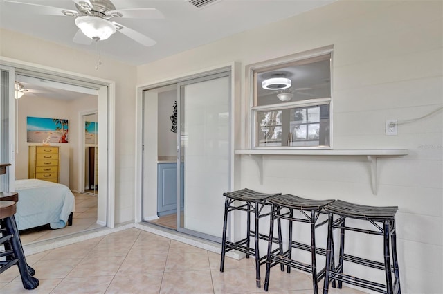 tiled dining space with ceiling fan