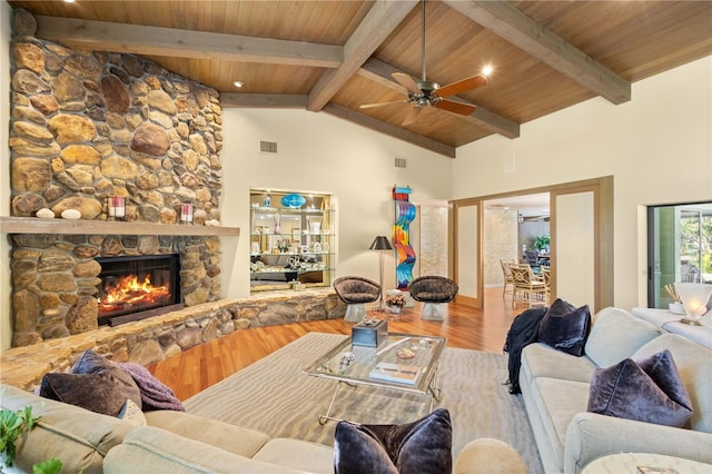 living room with a stone fireplace, ceiling fan, wooden ceiling, and wood-type flooring