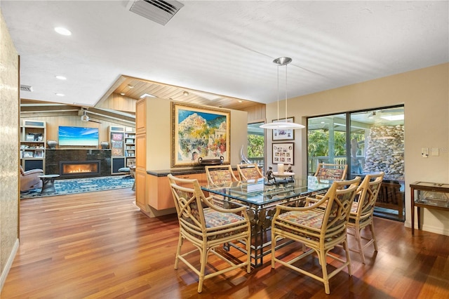 dining area with light wood-type flooring and a premium fireplace