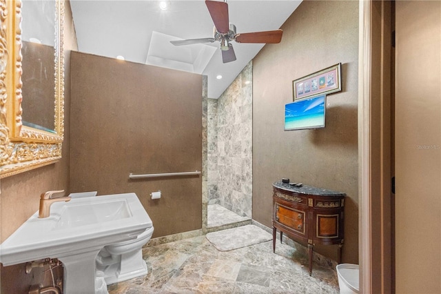 bathroom with tiled shower, ceiling fan, lofted ceiling, and sink