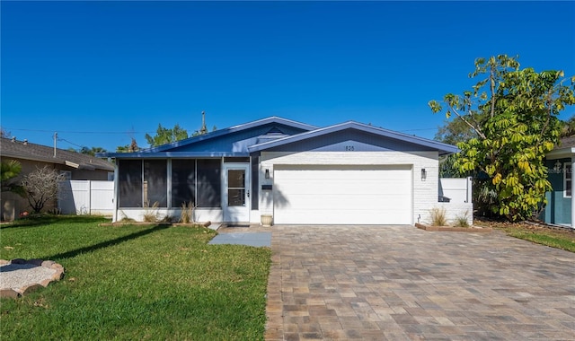 ranch-style home with a sunroom, a garage, and a front lawn