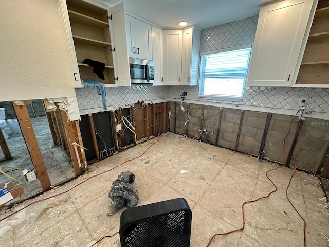 kitchen featuring white cabinets and backsplash