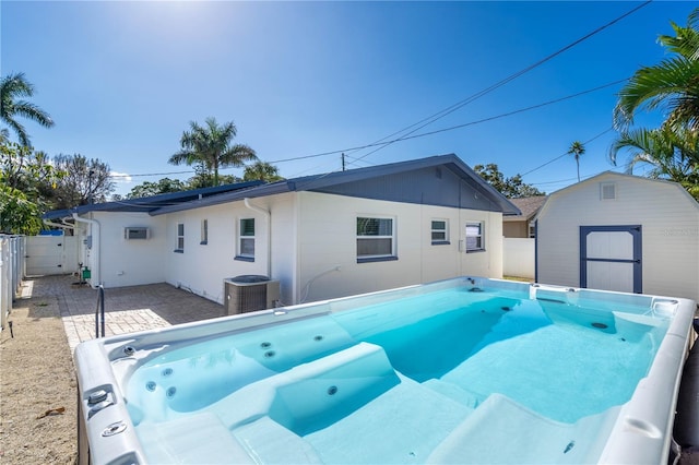 view of pool with central AC unit and a storage unit