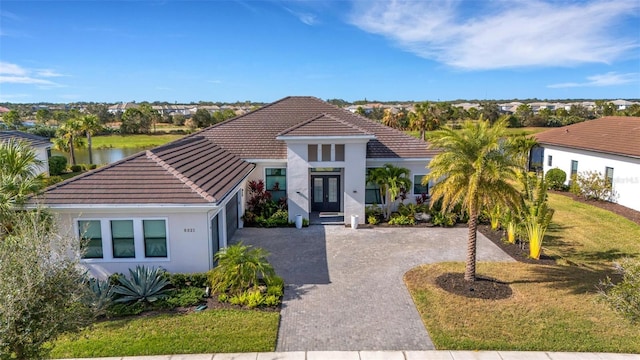 view of front of house featuring french doors, a water view, and a front yard