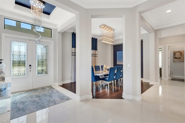 foyer entrance featuring tile patterned floors, a wealth of natural light, and a chandelier