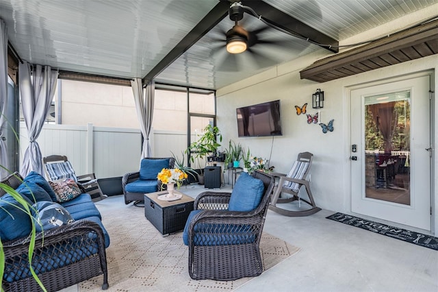 sunroom / solarium featuring beam ceiling and ceiling fan