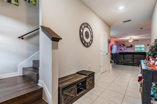 stairs featuring tile patterned floors and ceiling fan