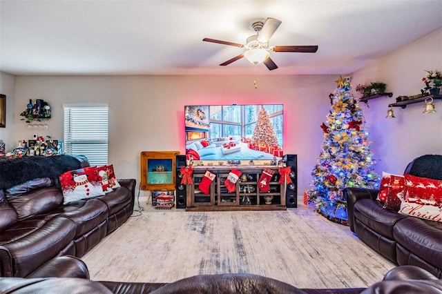 living room featuring wood-type flooring, ceiling fan, and a healthy amount of sunlight