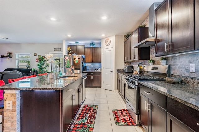 kitchen featuring decorative backsplash, sink, a center island with sink, and appliances with stainless steel finishes