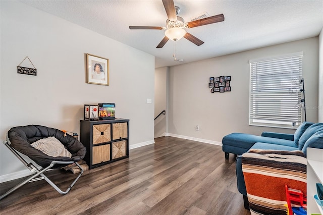 sitting room with ceiling fan, hardwood / wood-style floors, and a textured ceiling