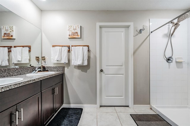 bathroom featuring a tile shower, tile patterned flooring, and vanity